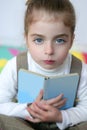 Beautiful preschooler girl studying book