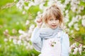 Beautiful preteen girl with long blond hair enjoy spring apple blooming. Little preschool girl in garden tree flowers. Springtime Royalty Free Stock Photo