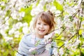 Beautiful preteen girl with long blond hair enjoy spring apple blooming. Little preschool girl in garden tree flowers. Springtime Royalty Free Stock Photo