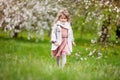 Beautiful preteen girl with long blond hair enjoy spring apple blooming. Little preschool girl runing  in garden tree flowers. Royalty Free Stock Photo