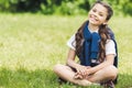 beautiful preteen schoolgirl sitting on grass