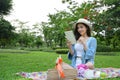 Beautiful pretty asian woman relaxing and thinking future plan to write something on diary book with smile face in the garden Royalty Free Stock Photo