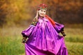 Beautiful pretty girl in national bright purple dress with red kerchief on her head, ornaments and embroidery. Colorful Royalty Free Stock Photo