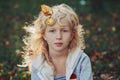 Beautiful pretty preschool Caucasian blonde girl with autumn leaves in long hair