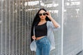 Beautiful pretty urban hipster woman in a vintage summer jacket in stylish sunglasses in a black t-shirt