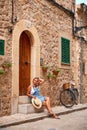 Beautiful pretty woman walking at old town pavement street with flowers and looking away. Travel concept Royalty Free Stock Photo