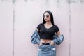 Beautiful pretty young brunette woman with long hair in sunglasses in a vintage blue skirt in a stylish black top Royalty Free Stock Photo