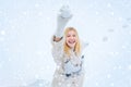 Woman in snow. Beautiful pretty young woman in winter. Young blond woman in sweater and funny hat holding white skates Royalty Free Stock Photo