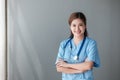 Beautiful and professional Asian female doctor in uniform with stethoscope open palm, smiling, looking at camera Royalty Free Stock Photo