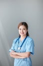 Beautiful and professional Asian female doctor in uniform with stethoscope open palm, smiling, looking at camera Royalty Free Stock Photo
