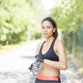 Beautiful professional athlete woman with water bottle after exercising.