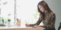 Beautiful professional businesswoman writing down her idea on notebook while working Royalty Free Stock Photo