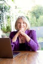 A beautiful professional senior woman working on her laptop from home