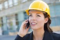 Beautiful Professional Young Woman Contractor Wearing Hard Hat on Site Using Phone