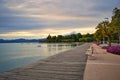promenade pier of Bardolino, lake Garda with benches, flowers, trees, water and dramatic evening sky Royalty Free Stock Photo