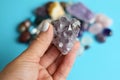 Beautiful purple amethyst crystals in hand. Druse of amethyst in a woman`s hand against the background of other precious stones. Royalty Free Stock Photo