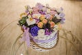 Beautiful purple bouquet of mixed flowers in basket on table Royalty Free Stock Photo