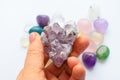 Beautiful purple crystals of amethyst in hand. Druse amethyst in the shape of a heart on the background of other gemstones Royalty Free Stock Photo