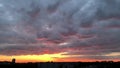 Beautiful purple sunset with huge clouds and city skyline