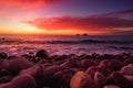 Purple tinted waves breaking on a rocky beach at sunset over Porth Nanven in the Cot Valley of Cornwall, England