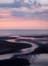 Beautiful purple twilight over a calm sea with water on the beach reflecting colorful sunset clouds Royalty Free Stock Photo