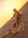 Beautiful queen of the desert in a luxurious gold dress.