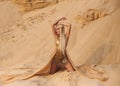 Beautiful queen of the desert in a luxurious gold dress.