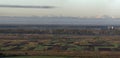 Beautiful quiet spring panorama of plowed and green fields and meadows on background of trees, forest and distant view of magnific Royalty Free Stock Photo