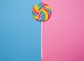 Beautiful rainbow lollipop on a pink and blue background Royalty Free Stock Photo
