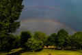 Beautiful rainbow in the sky in the park with green trees Royalty Free Stock Photo