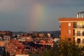 Rainbow in a city with houses and hills