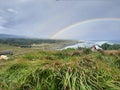 Beautiful double rainbow on the shore captured from the bushy hills