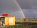 Beautiful rainbow after a thunderstorm in the sky in summer in the village