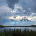 Beautiful rainy clouds in the dramatic sky over the lake