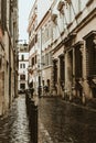Beautiful rainy street of Rome with people under umbrella silhouettes for lifestyle design. Summer season. Dark and