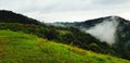 Beautiful range of green mountain, white cloud, small village and mist in the morning with copy space. Royalty Free Stock Photo