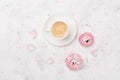 Beautiful ranunculus flowers and cup of coffee on white table top view. Breakfast in pastel color. Flat lay style.