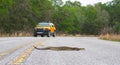 Beautiful rattlesnake crossing busy road with traffic on pavement or asphalt road. Eastern Diamondback - adamanteus crotalus -