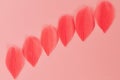 Beautiful Real feathers trend color coral on pink background closeup.
