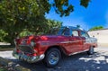 Beautiful red american classic Cabriolet car parked under palms in Varadero - Serie Kuba 2016 Reportage