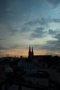 Beautiful red and blue sunrise sky with clouds over black silhouette of city with tower of church on horizon. Silhouette of the Royalty Free Stock Photo