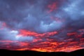 Beautiful red-blue sunset over the city with dark clouds. Dark silhouette of the city with a beautiful dawn. Artistically blurry Royalty Free Stock Photo