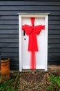 Beautiful red bow tied on a exterior door, a Christmas decoration.
