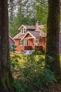 Beautiful red brick single family home with green grass and large trees. Big house with porch surrounded by nice nature