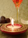 Beautiful red candle and glass, sweets on a background