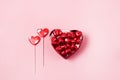 Beautiful Red Chocolate Hearts Candies in Red Box and Red Lollipop Shape of Heart on Pink Background St Valentine Day Background