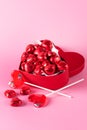 Beautiful Red Chocolate Hearts Candies in Red Box and Red Lollipop Shape of Heart on Pink Background St Valentine Day Background