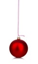 Beautiful red Christmas ball hanging with pink ribbon on a white background. Royalty Free Stock Photo