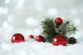 Beautiful red Christmas balls and fir tree branch on snow, bokeh effect Royalty Free Stock Photo