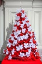 Beautiful red Christmas tree with ribbon bows decorations. New Year, winter holidays selebration